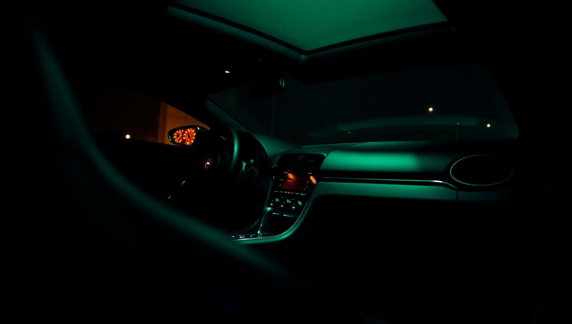 Luxury car interior bathed in neon green ambient light